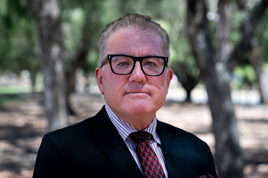 A man in a suit wearing glasses.