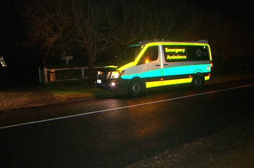 An ambulance parked on the side of the road with its lights flashing