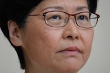 A close up shot of Carrie Lam, who wears a serious expression on her face.