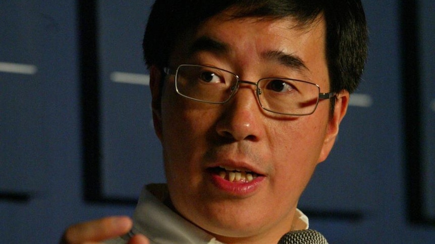 Chinese businessman speaking, while holding microphone