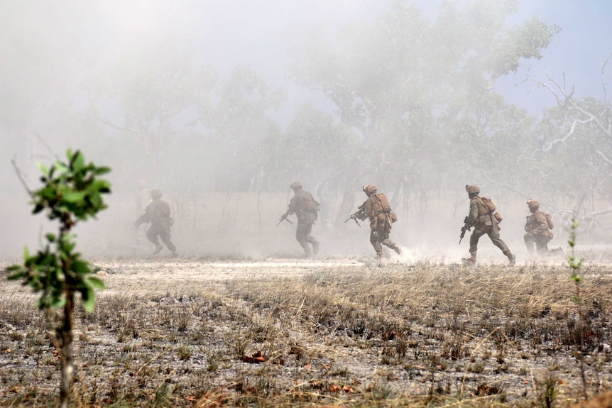 US Marines run through smoke and dust in Australian scrubland