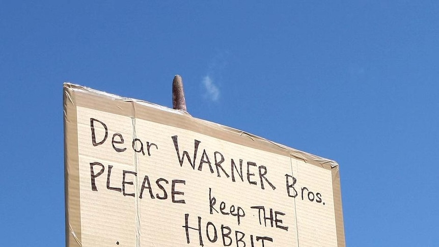 A sign is held up as protestors rally about the making of The Hobbit movies