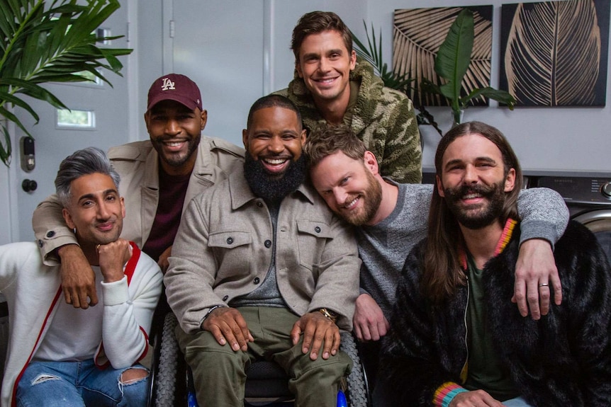 Wesley Hamilton is surrounded by the cast. All are smiling at the camera