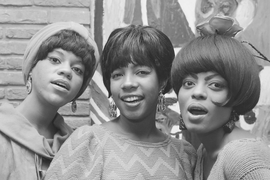 A black and white photo showing three woman with short hair.