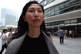 Young professional lady walks through streets of modern Chinese city.