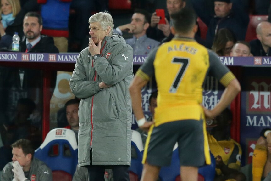Arsenal manager Arsene Wenger looks on as striker Alexis Sanchez watches him against Crystal Palace.