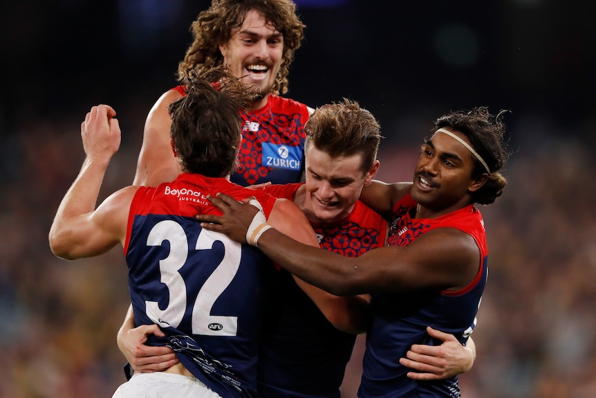 Bayley Fritsch is in the middle of a pack of Melbourne players who are congratulating him
