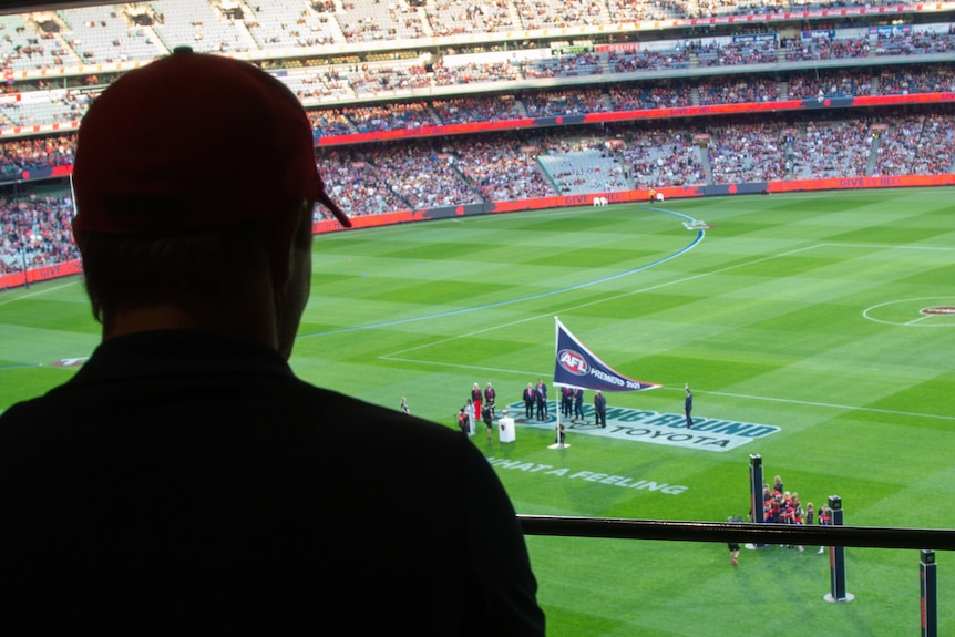 Fans watch as the Demons unfurl the 2021 premiership flag at the MCG 