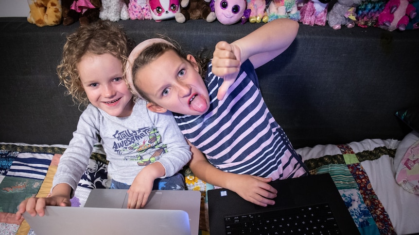 Two kids on laptops in a story about reducing screen time and technology use to better engage with children.