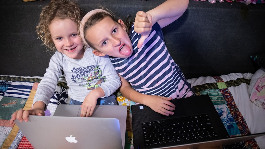 Two kids on laptops in a story about reducing screen time and technology use to better engage with children.
