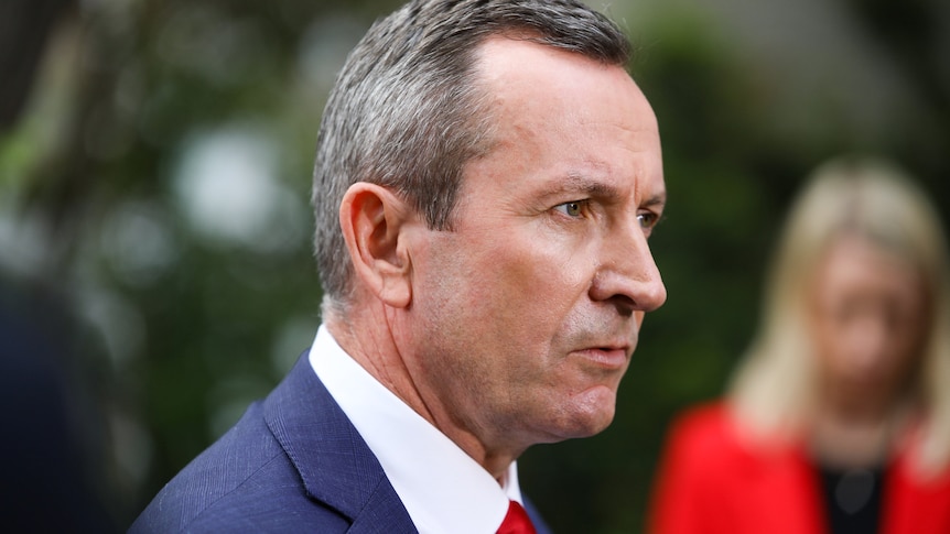 A side-on head and shoulders shot of WA Premier Mark McGowan speaking at a media conference outdoors.