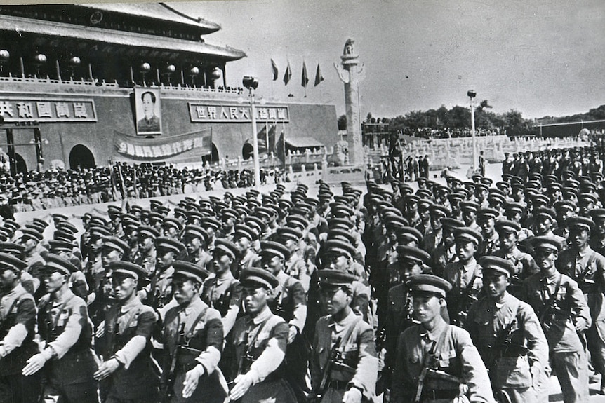 A black and white image of regimented Chinese soldiers marching through Tiananmen square