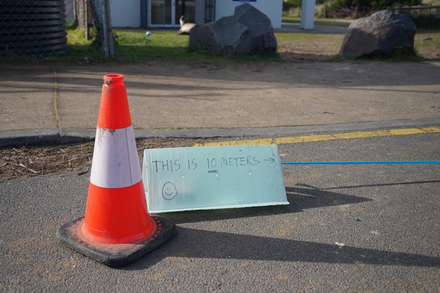 An orange traffic cone with a sign reading: this is 10 megtres