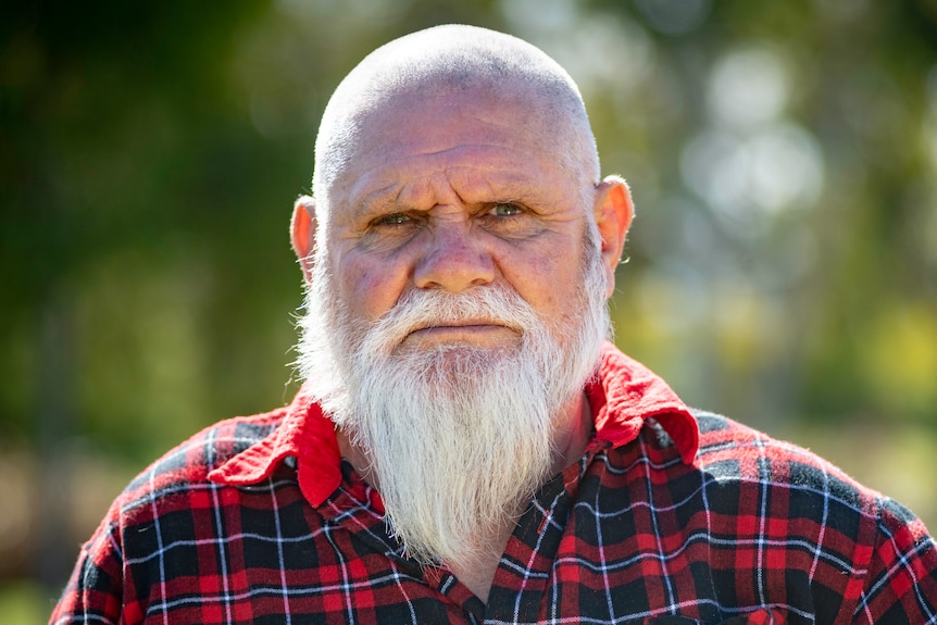 A man with a St Kilda Football Club shirt on looks at the camera.