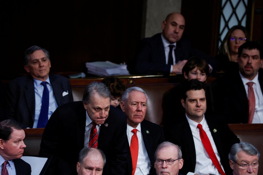 Men in suits sitting in the US House chamber