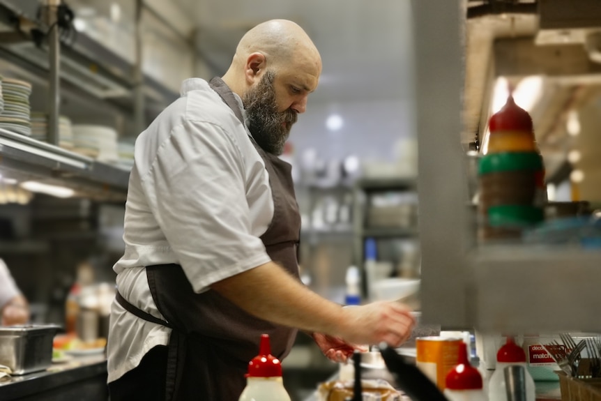 A kitchen worker prepares food at the Golden Sheath Hotel