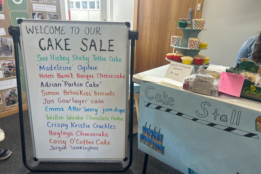 A white board with a list of cakes