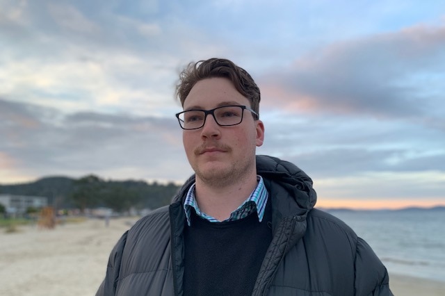 Jake Vincent stands on a beach