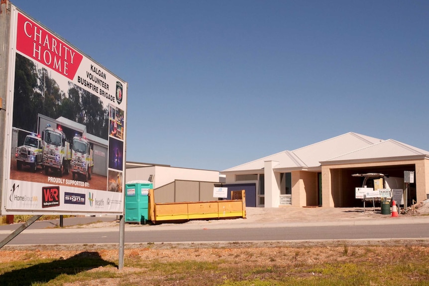 A sign outside a house under construction advertises it as a charity home for auction to raise funds for a fire brigade.