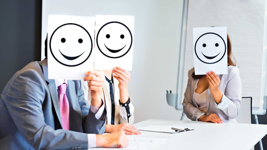 Business team holding happy smile sign