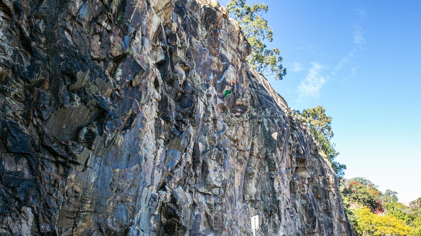 A rock climber coming down a rock face.