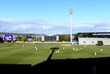 A wide shot of Bellerieve Oval, with shadows lengthening over cricketers on the field