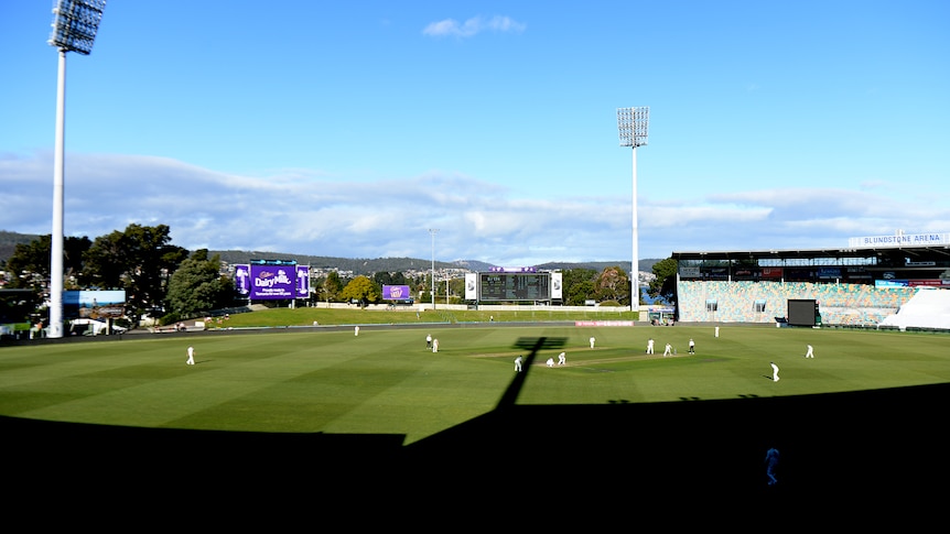 A wide shot of Bellerieve Oval, with shadows lengthening over cricketers on the field