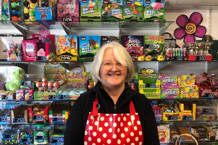 Woman stands in front of shelves filled with confectionery