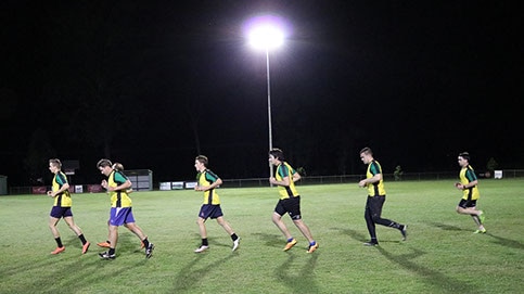 Logan Village men's football team in the country's most marginal seat of Forde running across a field