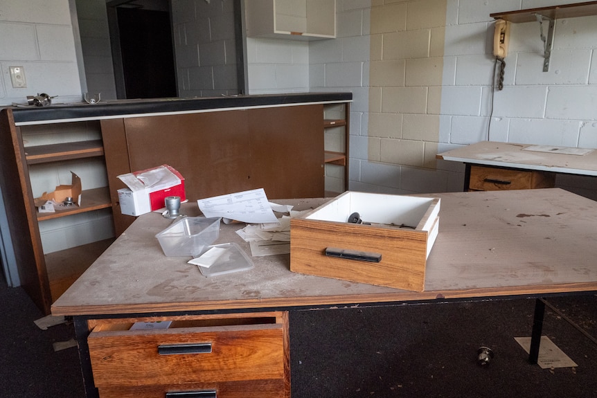 A dusty desk with paperwork on it at the abandoned BHP accommodation Moranbah, Queensland, November 2021.