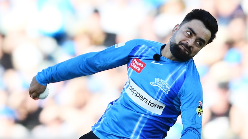 Rashid Khan leans forward with his right arm behind him in his bowling action for the Adelaide Strikers in the BBL.