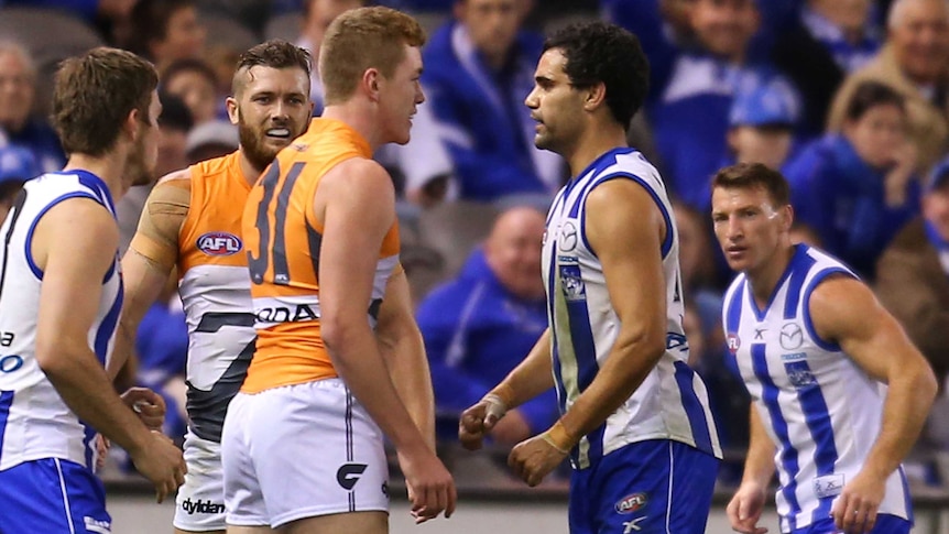 Lindsay Thomas of the Kangaroos (R) and the Giants' Jacob Townsend confront each other at Docklands.