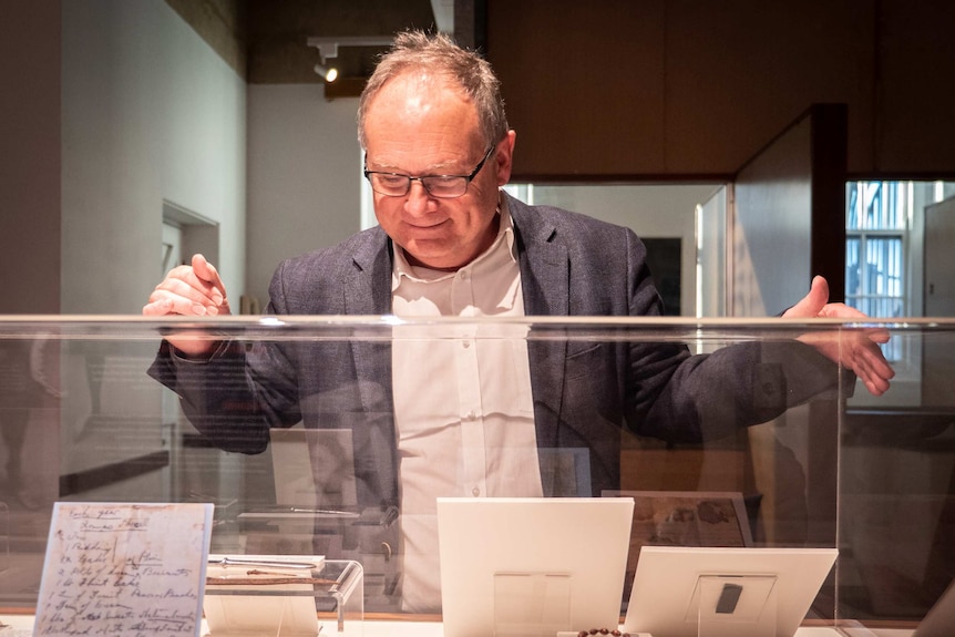 Minister for heritage David Templeman inspects the finds in a glass case at Fremantle Prison.