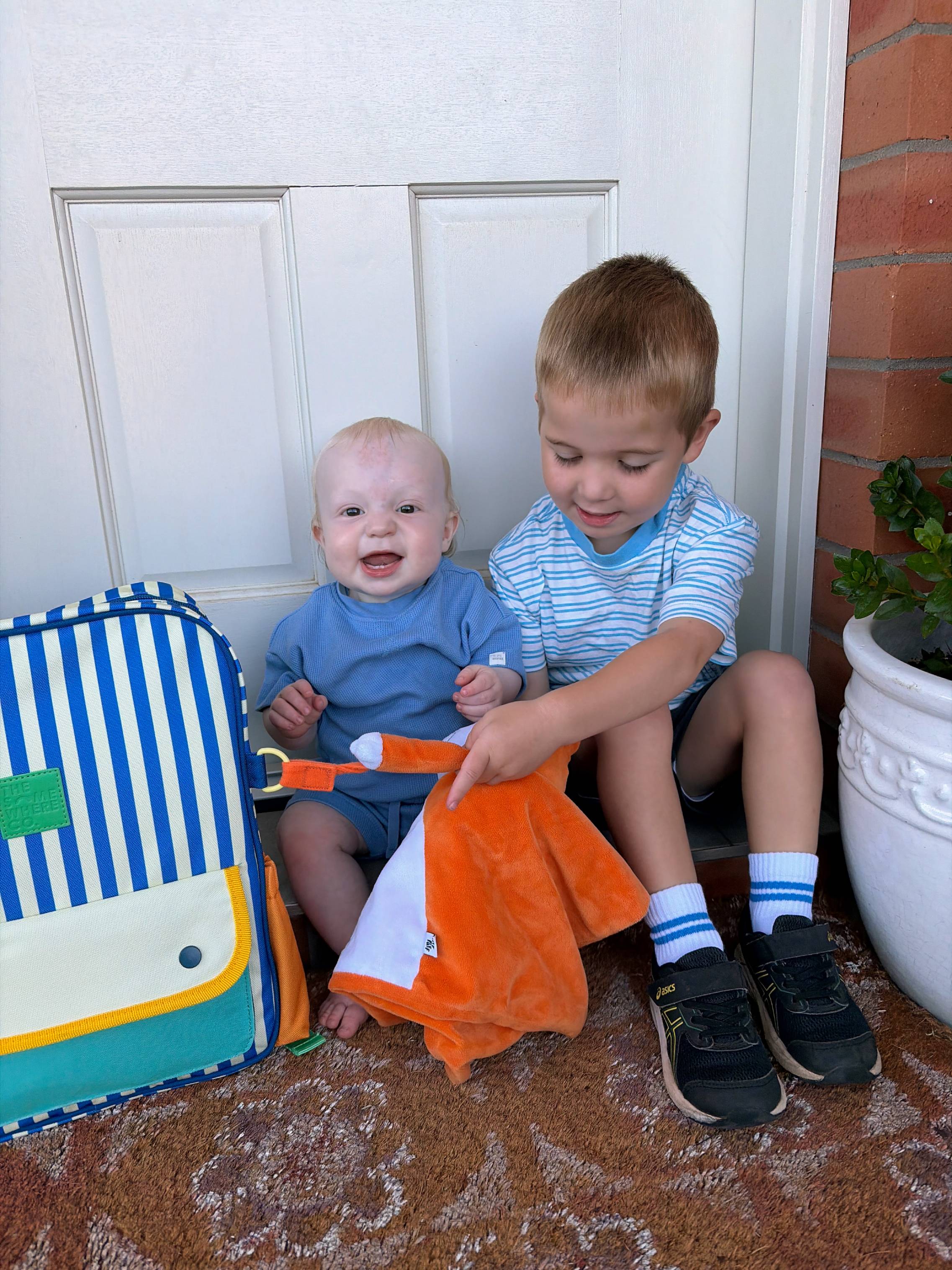 two boys sitting on a porch step