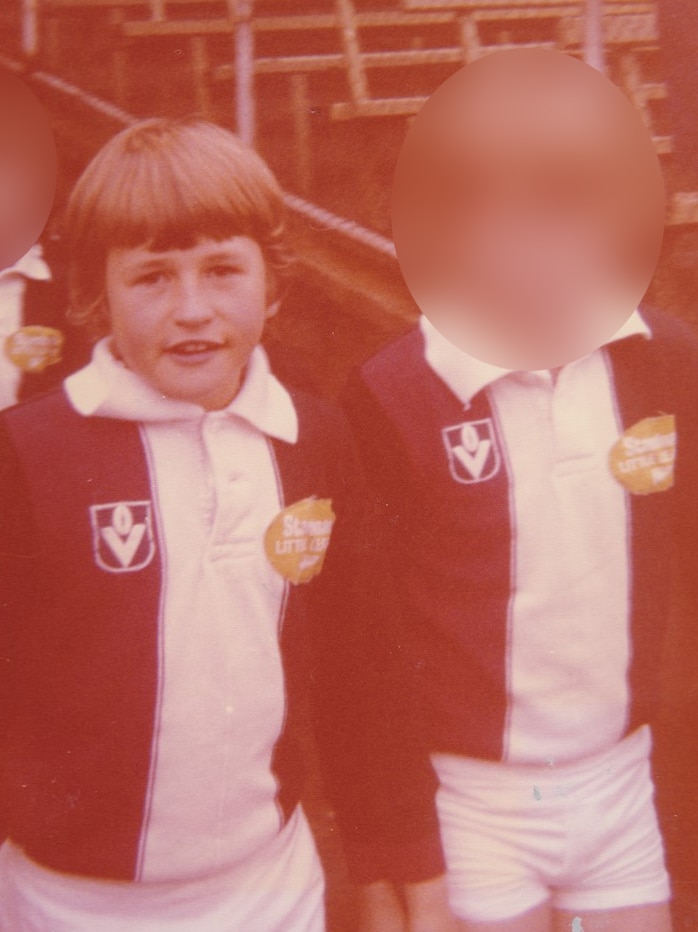 A young boy in a St Kilda guernsey looks at the camera.