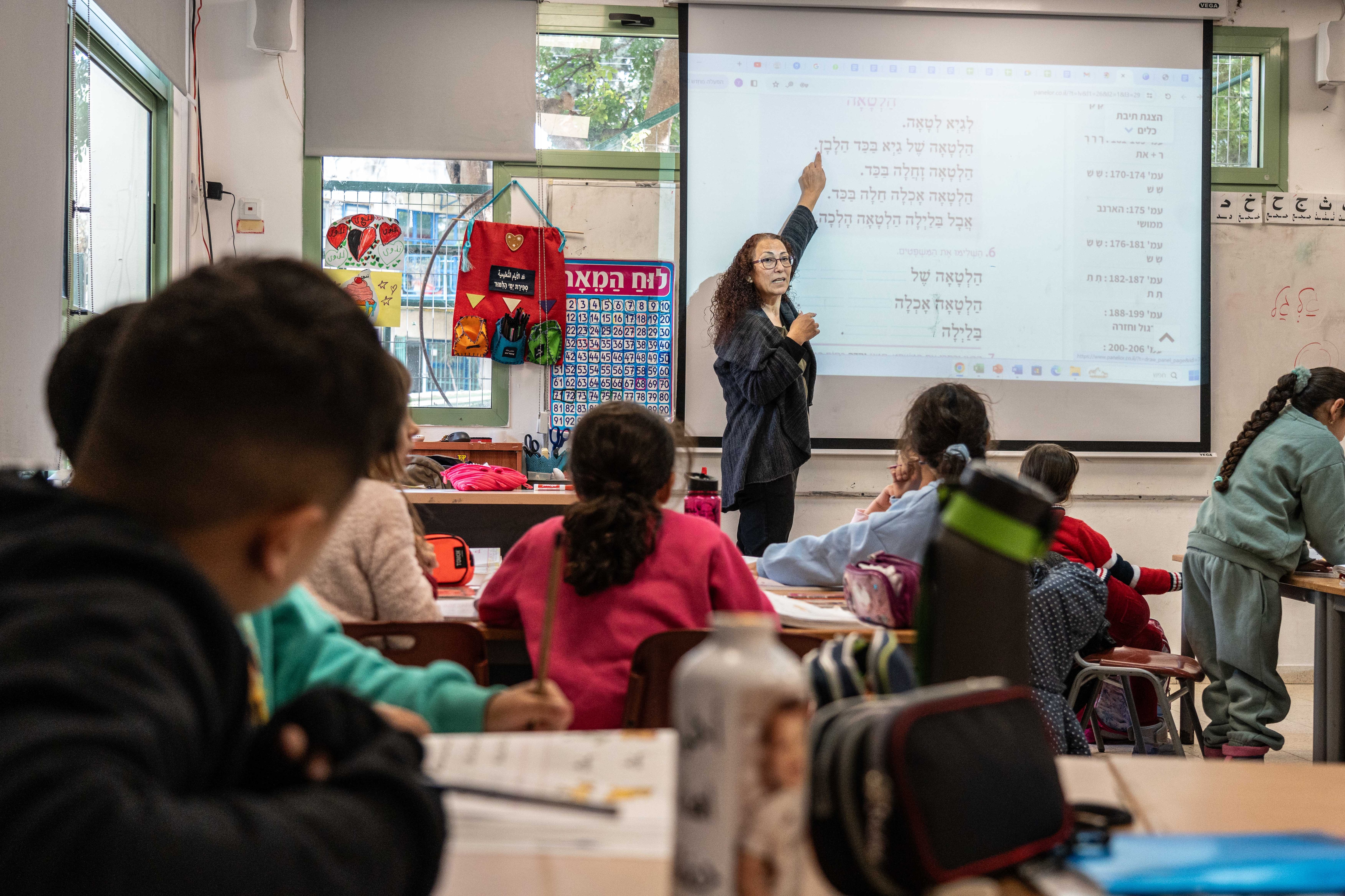 Woman teaching a classroom with Palestinian and Jewish children.