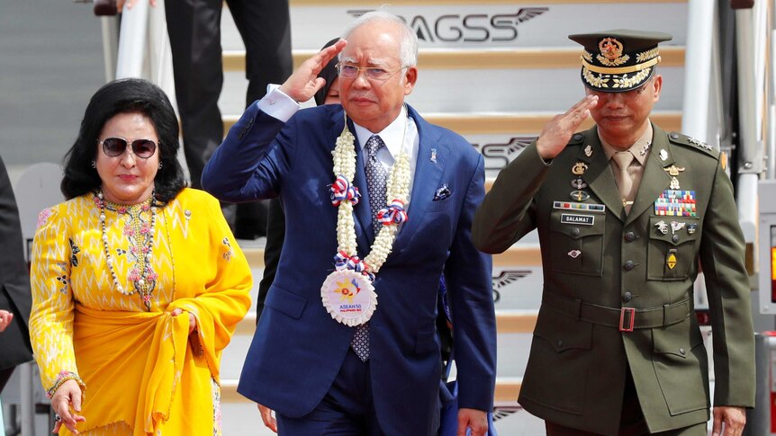 Najib Razak salutes the honour guards, next Rosmah Mansor, upon arrival in the Philippines for the 2017 ASEAN Summit.