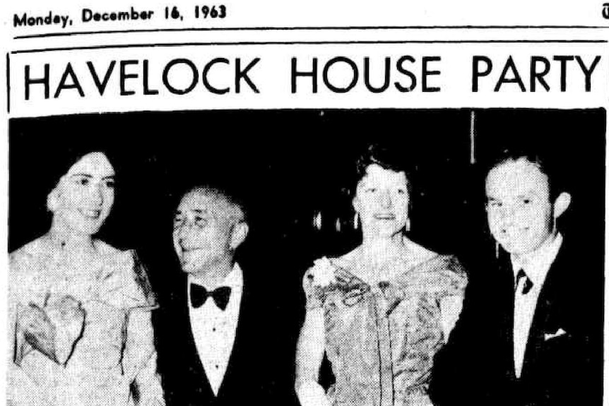Four people dressed in black tie and ball gowns stand together at a Havelock House dinner party