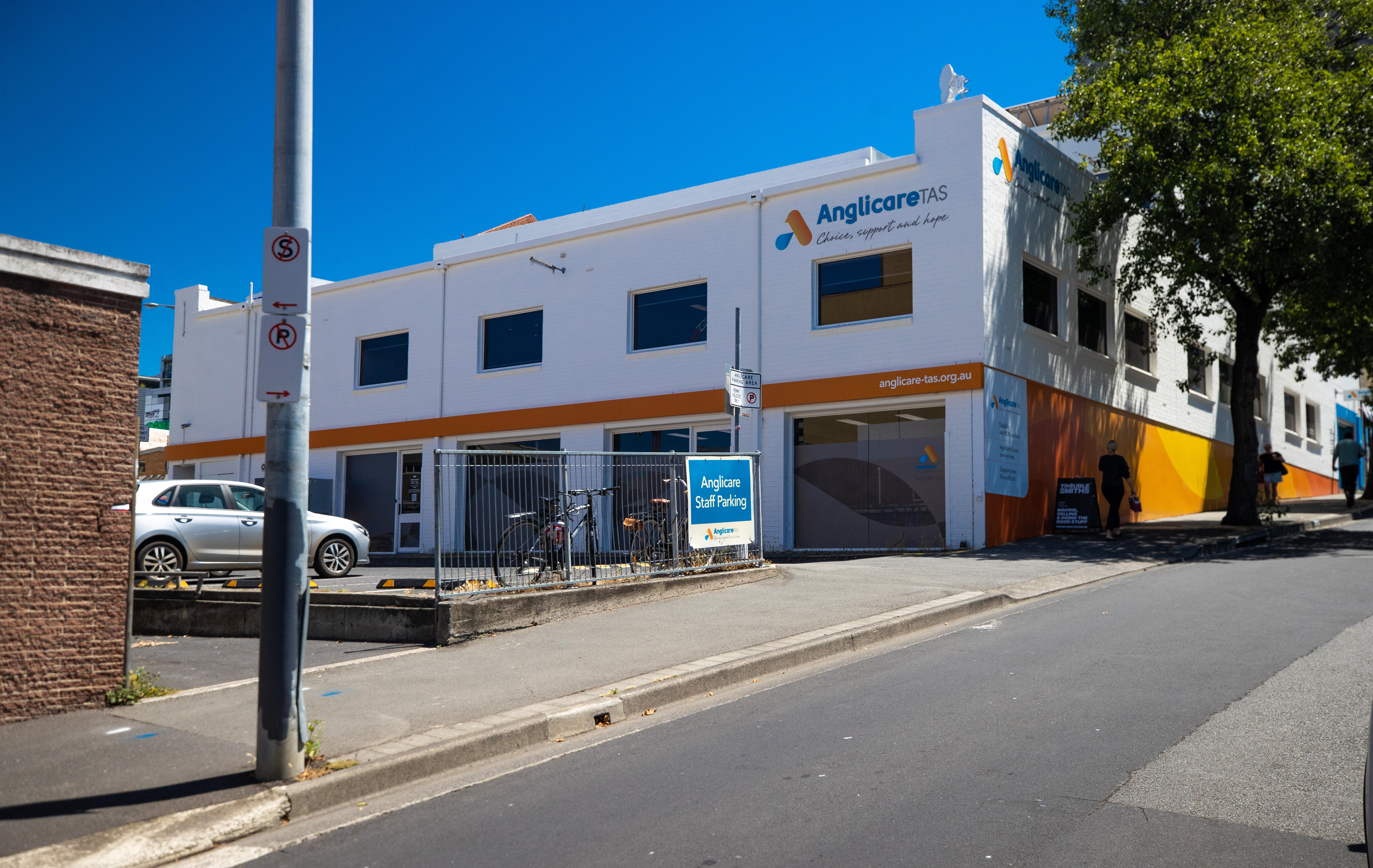 在晴朗的日子里，可以看到 Anglicare Tasmania 的建筑紧挨着街道。