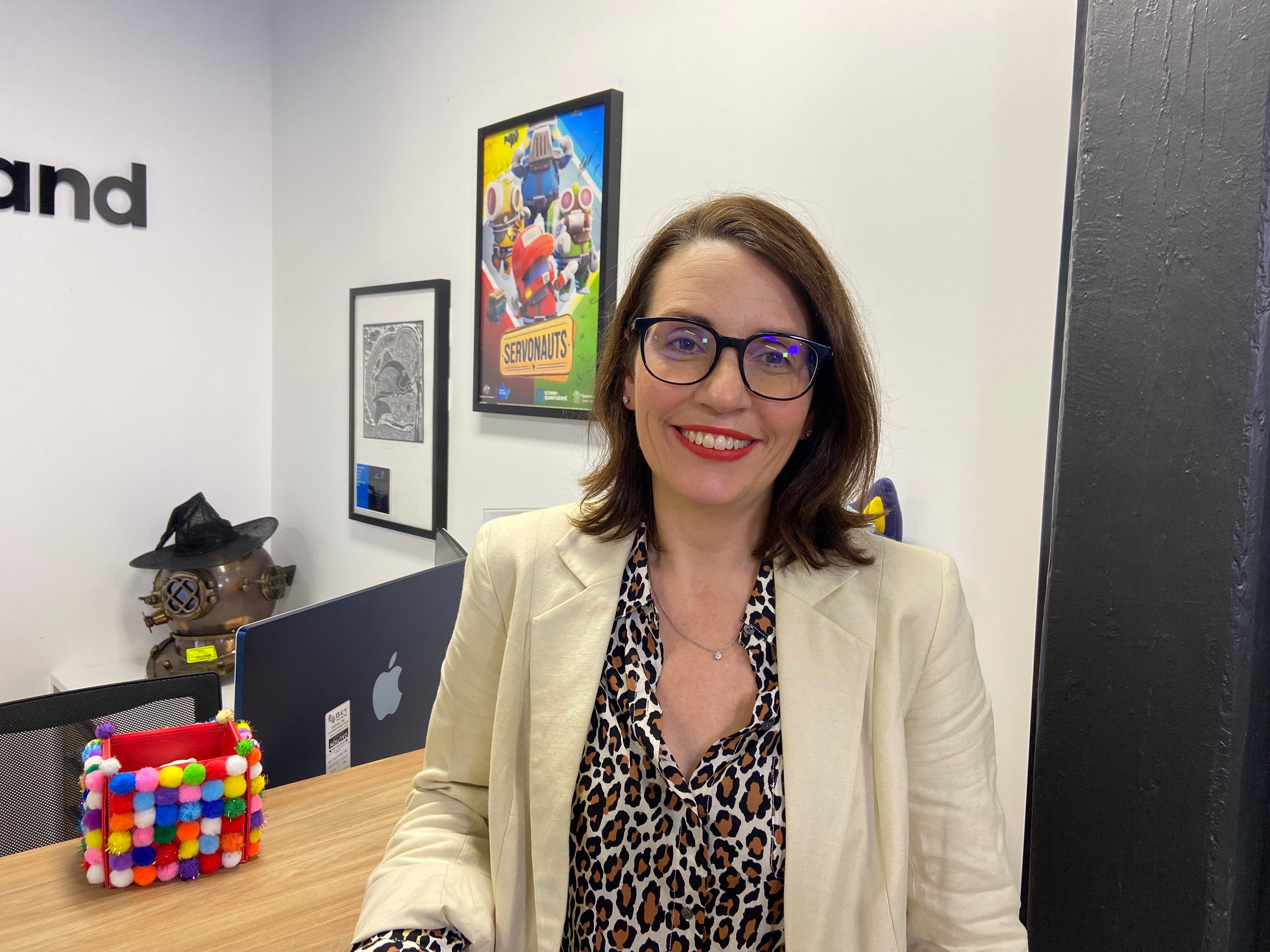 Dr Belinda Burns has shoulder length hair and wears glasses.