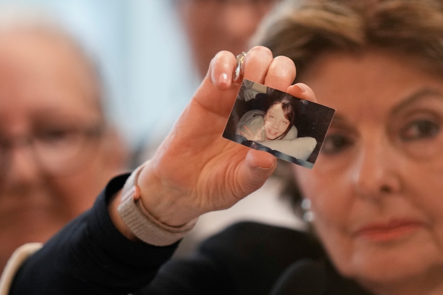 Attorney Gloria Allred holds up a picture of Jessica Taylor during a news conference after the hearing. 