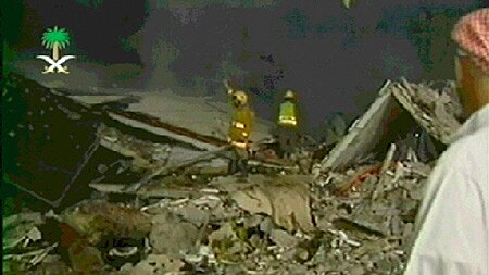 Rescue workers sift through the rubble of a building in the Muhaya compound.