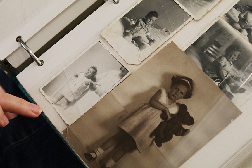 Page of a photo album holding black and white baby photos.