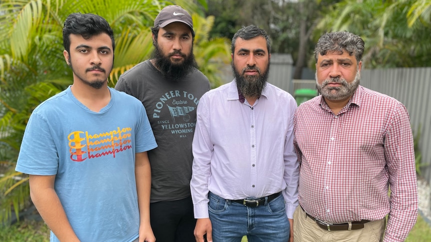 An Afghan family of four standing side by side in their Gold Coast backyard
