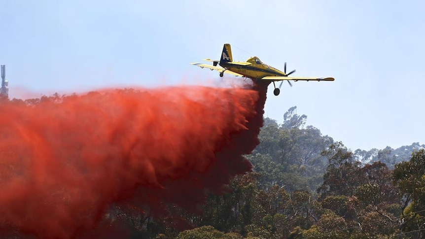 Water bomber dumps fire retardant on bushfires
