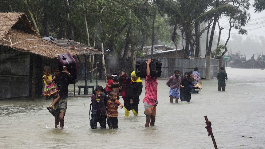 Bangladeshi villagers make their way to shelter in Cox's Bazar