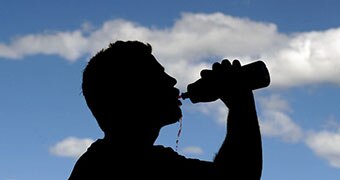 A sportsman takes a drink following a training session