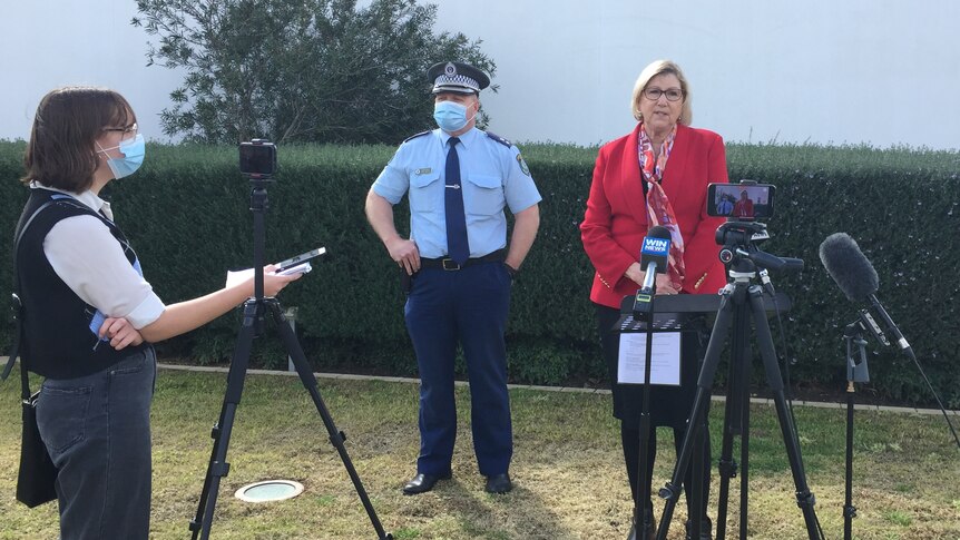 A police man and woman address the media at a press conference