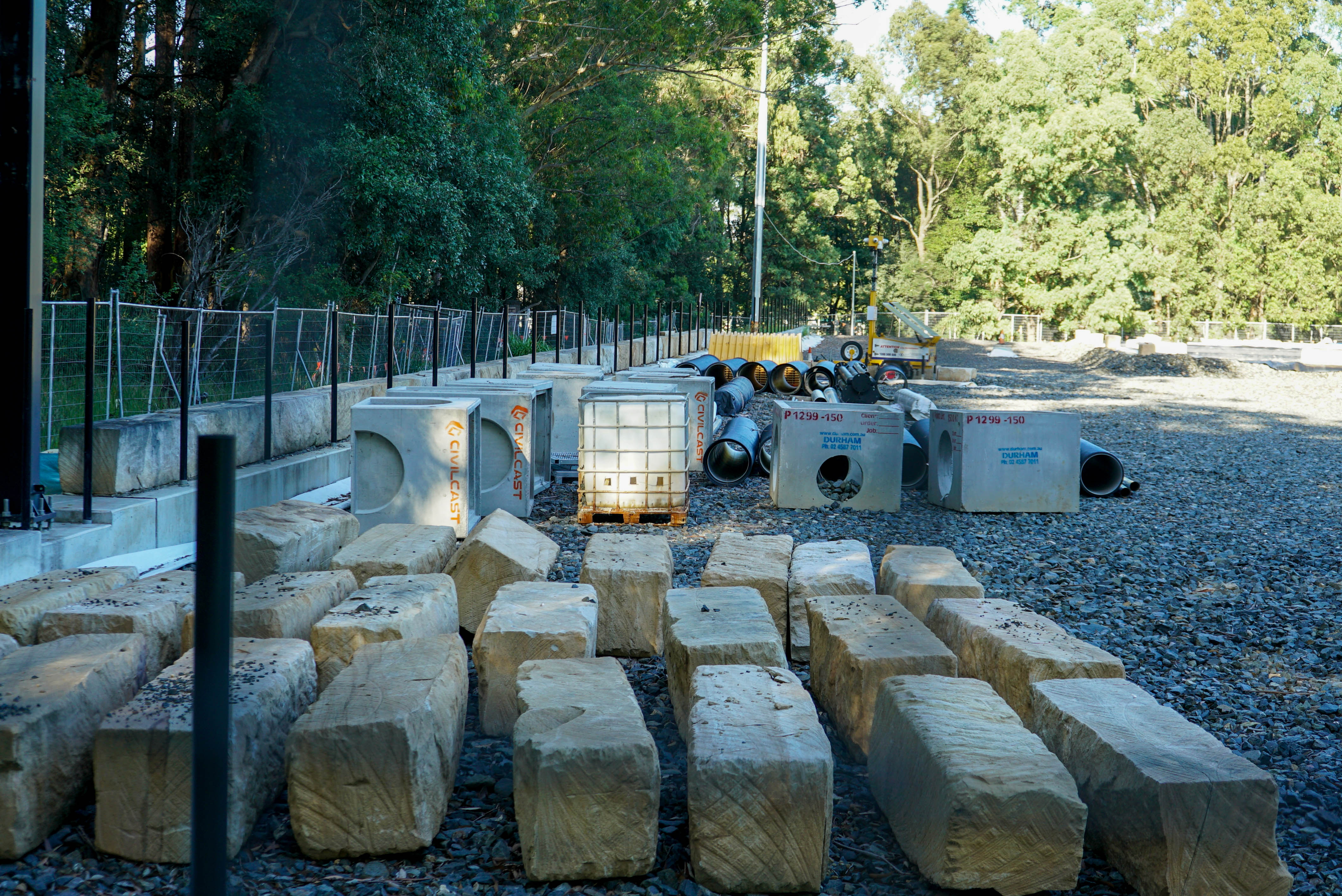 materiais de construção organizados ao ar livre em um campo de futebol coberto de cascalho