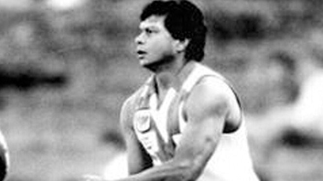 Northern Territory-born football star Maurice Rioli handballs during a game.